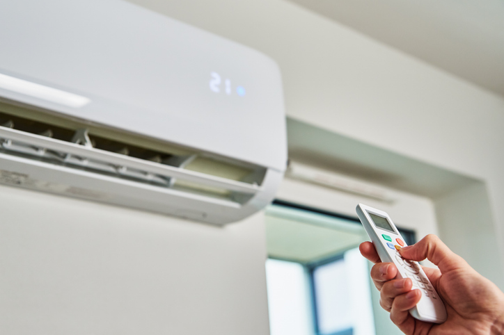 hand-adjusting-temperature-on-air-conditioner